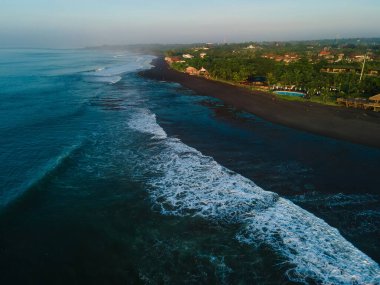 Keramas, Bali 'de okyanus dalgaları olan siyah kumsal manzarası.