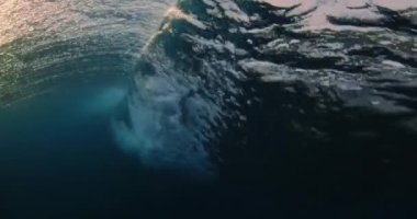 Okyanus varili dalgasının sualtı görüntüsü köpük ve kabarcıklarla kırılıyor.