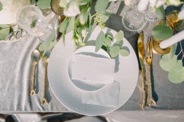 Masa örtüsü üzerinde üst görünümü ayarlayan asgari masa yerindeki kağıt kağıdı modeli. Mesaj için yer var. Davetiyeli düğün masası.