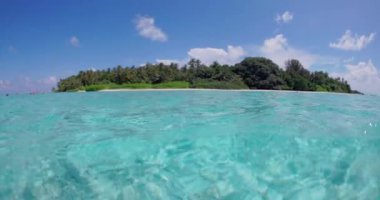 Şeffaf okyanus ve Maldivler 'deki tropikal ada manzarası. Yüksek kalite 4k görüntü