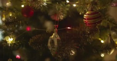 Yeni yılınız kutlu olsun Noel ağacı, arkaplandaki karla süslenir. Kış tatilinde aile tatili için yanıp sönen ampuller. Yüksek kalite 4k görüntü