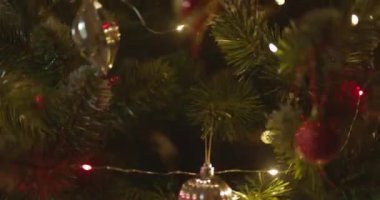 Yeni yılınız kutlu olsun Noel ağacı, arkaplandaki karla süslenir. Kış tatilinde aile tatili için yanıp sönen ampuller. Yüksek kalite 4k görüntü