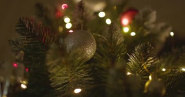 Yeni yılınız kutlu olsun Noel ağacı, arkaplandaki karla süslenir. Kış tatilinde aile tatili için yanıp sönen ampuller. Yüksek kalite 4k görüntü