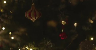 Yeni yılınız kutlu olsun Noel ağacı, arkaplandaki karla süslenir. Kış tatilinde aile tatili için yanıp sönen ampuller. Yüksek kalite 4k görüntü