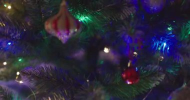 Yeni yılınız kutlu olsun Noel ağacı, arkaplandaki karla süslenir. Kış tatilinde aile tatili için yanıp sönen ampuller. Yüksek kalite 4k görüntü