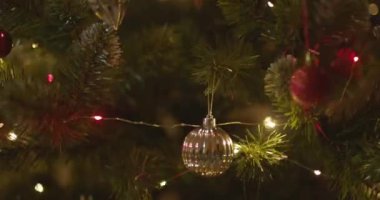 Yeni yılınız kutlu olsun Noel ağacı, arkaplandaki karla süslenir. Kış tatilinde aile tatili için yanıp sönen ampuller. Yüksek kalite 4k görüntü