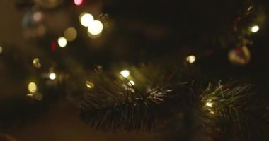 Yeni yılınız kutlu olsun Noel ağacı, arkaplandaki karla süslenir. Kış tatilinde aile tatili için yanıp sönen ampuller. Yüksek kalite 4k görüntü