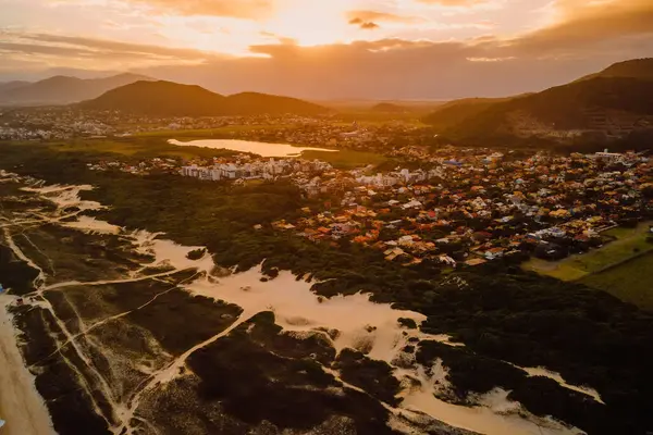 stock image Coastline with dunes and Campeche town with sunset lights in Florianopolis