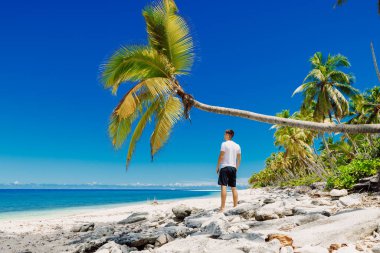 Kumsalda dinlenen bir adam. Cennet sahilinde zayıf adam tatili