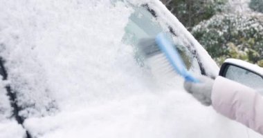 Arabanın yan camlarından kar temizleyen kadın. Yüksek kalite 4k görüntü