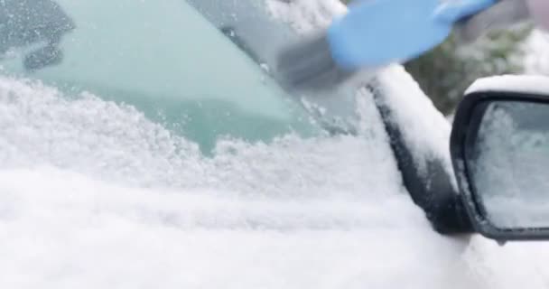 車のサイドウィンドウからブラシで雪を掃除する女性 高品質の4K映像 — ストック動画