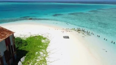 Kaafu Mercan 'ındaki Maafushi yakınlarındaki Gulhi adasının havadan görüntüsü. Açık okyanusu ve plajı olan tropik bir ada, Maldivler. Yüksek kalite 4k görüntü