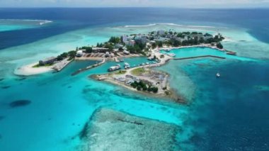 Kaafu Mercan 'ındaki Maafushi yakınlarındaki Gulhi adasının havadan görüntüsü. Açık okyanusu ve plajı olan tropik bir ada, Maldivler. Yüksek kalite 4k görüntü