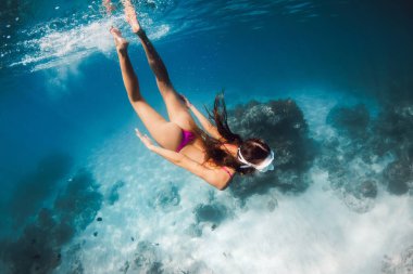 Mavi denizde şnorkelle yüzen mükemmel vücutlu bir kadın. Oahu 'da okyanusun altında yüzmek.