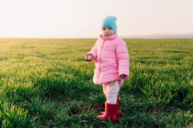 Küçük tatlı kız tarlada kürekle toprağı kazıyor