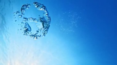 Halka, açık mavi denizde suyun altında kabarcıklar oluşturur. Yüksek kalite 4k görüntü