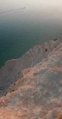 Dağ kıyıları, gün batımında sıcak tonlarla, dikey görüntülerle. Yüksek kalite 4k görüntü