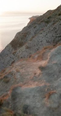 Dağ kıyıları, gün batımında sıcak tonlarla, dikey görüntülerle. Yüksek kalite 4k görüntü