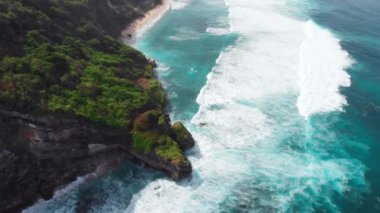 Kaya uçurumlu tropik plaj ve sörf dalgalı mavi okyanus. Yüksek kalite 4k görüntü