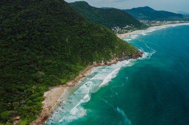 Brezilya 'da dağlar ve dalgalı okyanus manzaralı kıyı şeridi. Panoramik dron görünümü