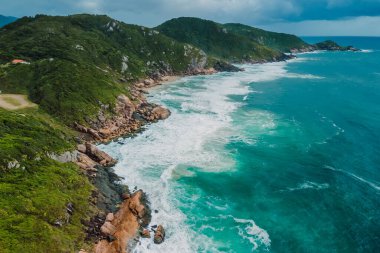 Brezilya 'da dağlar ve dalgalı okyanus manzaralı kıyı şeridi. Panoramik dron görünümü