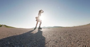 Güneşli bir günde dışarıda paten kayan güzel bir genç kadın. Yüksek kalite 4k görüntü