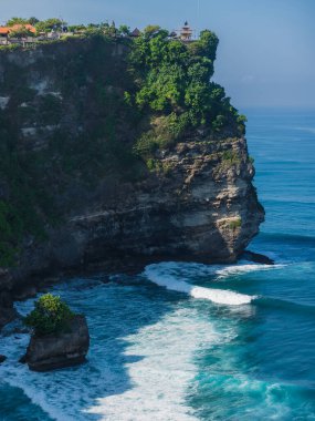Popüler turistik bir yer ve bale tapınağı. Uluwatu, Bali 'de sabah ışığı ve dalgalı okyanus manzaralı uçurum.