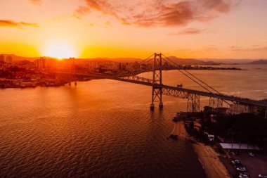 Şehrin insansız hava aracı görüntüsü ve Hercilio luz köprüsü ile Florianopolis, Brezilya 'da gün batımı