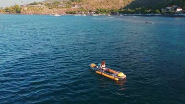 Mavi okyanusta kayak yapan bir kadın. İHA görüntüsü, tepeden tırnağa. Yüksek kalite 4k görüntü