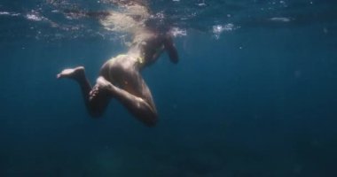 Seksi kadın şeffaf tatlı su gölünde yüzüyor, sualtı manzaralı. Yüksek kalite 4k görüntü