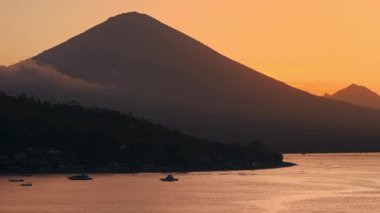 Gün batımında kıyı şeridi ve volkan dağı. Amed, Bali 'de İHA görüntüsü. Yüksek kalite 4k görüntü