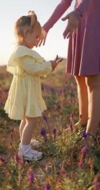 Güzel kız anne ile dışarıda kalıyor sıcak akşam güneşiyle. Yüksek kalite 4k görüntü