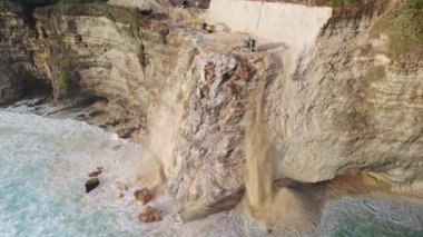 Uluwatu, Bali 'de kazı yapıyoruz. Yürüyen merdivenler Uluwatu Tapınağı yakınlarındaki kayayı yok ediyor. Yüksek kalite 4k görüntü