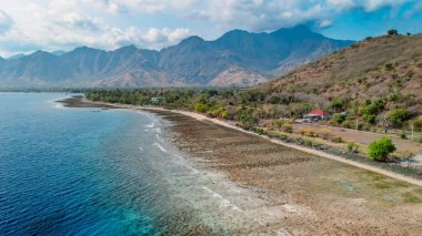 Pemuteran bölgesinde mavi okyanus ve dağlarla Batı Bali manzarası
