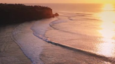 Sıcak gün batımı ya da gün doğumu ve Bali 'de mükemmel dalgaların silueti ile okyanus. Yüksek kalite 4k görüntü