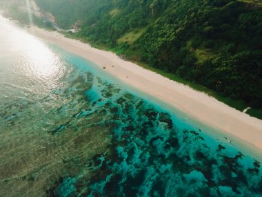 Bali adasında yeşil kayalıkları ve okyanusu olan manzaralı bir sahil. Tropikal tatil plajının havadan görünüşü