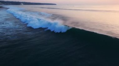 Dalgalarda sörf yapan drone görüntüsü. Bali 'de okyanusta sörfçülerle mükemmel dalgalar. Yüksek kalite 4k görüntü