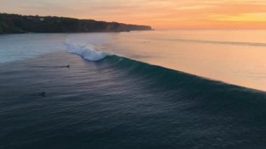 Dalgalarda sörf yapan drone görüntüsü. Bali 'de okyanusta sörfçülerle mükemmel dalgalar. Yüksek kalite 4k görüntü