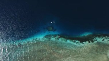 Bali 'deki kum tepesi adasıyla mercan resifi üzerinde deniz manzarası. Yüksek kalite 4k görüntü