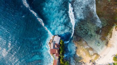 Scenic landscape with rocks on coastline and blue ocean with waves in Lembongan island, Bali. Aerial view clipart