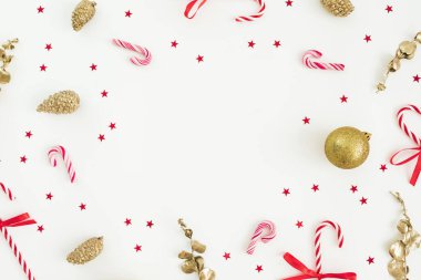 Noel kompozisyonu. Beyaz üzerine konfeti ve baston şekerle altın madalya. Düz yerde, üst tarafta. Yeni yıl tatili