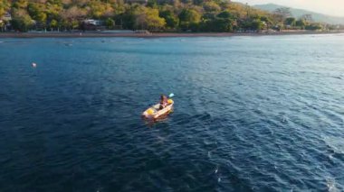 Mavi okyanusta kayak yapan bir kadın. İHA görüntüsü, tepeden tırnağa. Yüksek kalite 4k görüntü