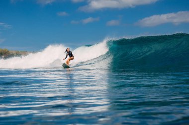 Sörf yaparken sörf tahtasındaki kadın sörfçü. Sörfçü kız ve okyanus dalgası