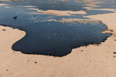 Bir tanker enkazından sonra deniz kıyısındaki yakıt deposu. Petrolle kirlenmiş plaj