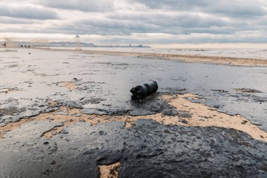 Okyanus kıyısındaki bir tanker kazasından sonra petrol. Kumsal yakıt ile kirlenmiş.