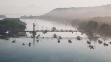 Dar bir okyanus kanalı üzerinde iki tropikal adayı birbirine bağlayan bir köprünün drone görüntüsü. Endonezya 'dan Nusa Lembongan ve Nusa Ceningan. Yüksek kalite 4k görüntü