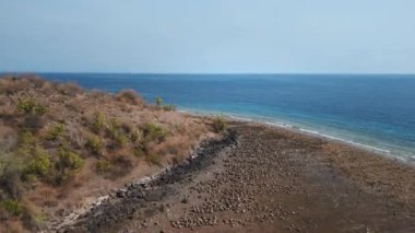 Mavi okyanus manzarası ve Batı Bali 'deki Pemuteran bölgesinde kavrulmuş savana bitkisi. Yüksek kalite 4k görüntü