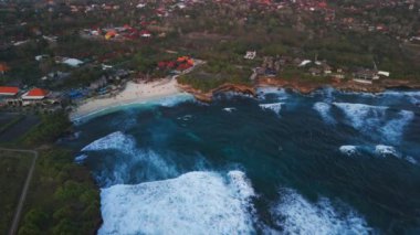 Nusa Lembongan adasının plaj, okyanus ve dalgalarla dolu kıyı şeridini gösteren statik dron görüntüsü. Yüksek kalite 4k görüntü