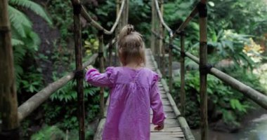 Tropikal yağmur ormanlarında bambu köprüsü ile yolda yürüyen ilk kişi. Yüksek kalite 4k görüntü