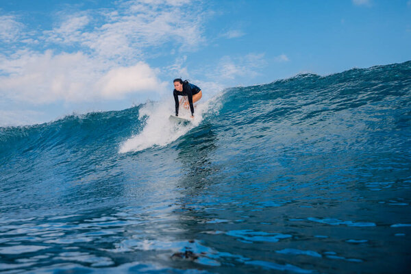 Серфингистка на доске для серфинга во время катания. Девочка-серфер всплыла на океанской волне